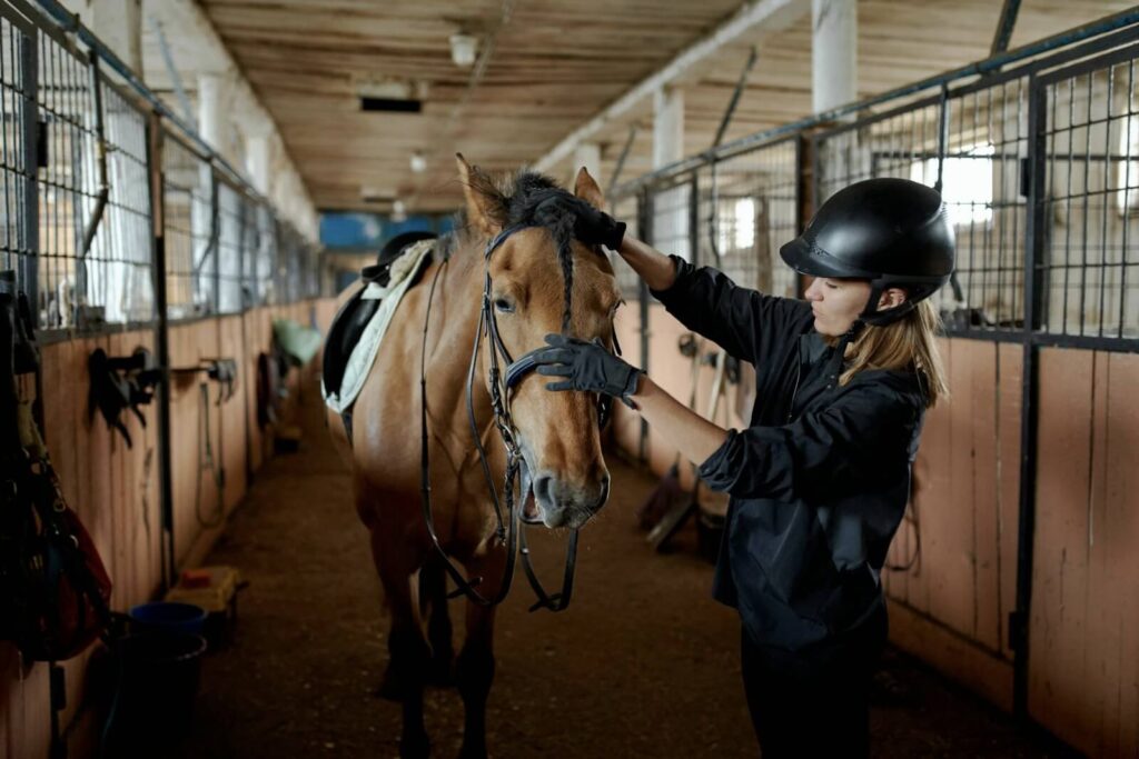 woman prepares to ride horse